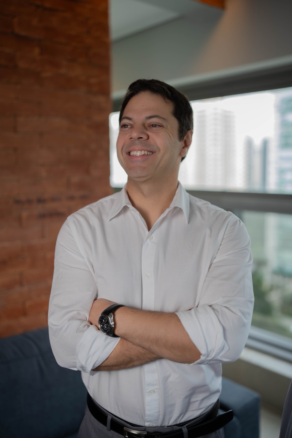 Dr. Flavio Pestilla Esperidião, urologista, sorrindo de braços cruzados em seu consultório